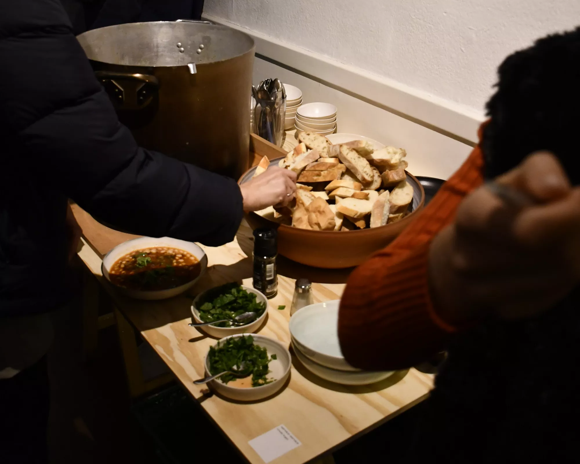 <p>A big pot of soup is served next to a handmade bowl of bread and other small bowls with herbs. All the tableware is made by Ursula Vogel.</p>